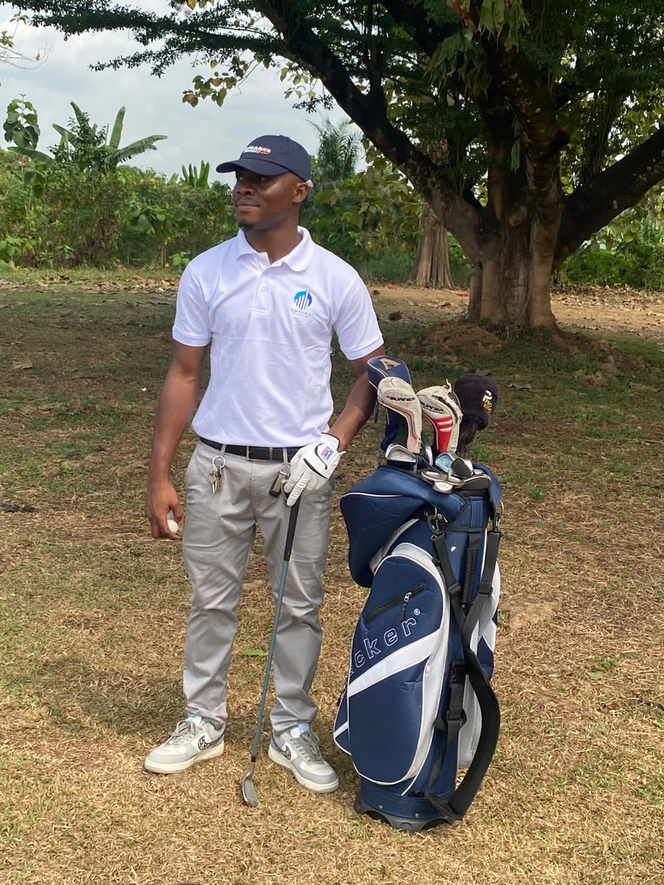Ikome Princewill standing beside a golf bag and clubs outdoors
