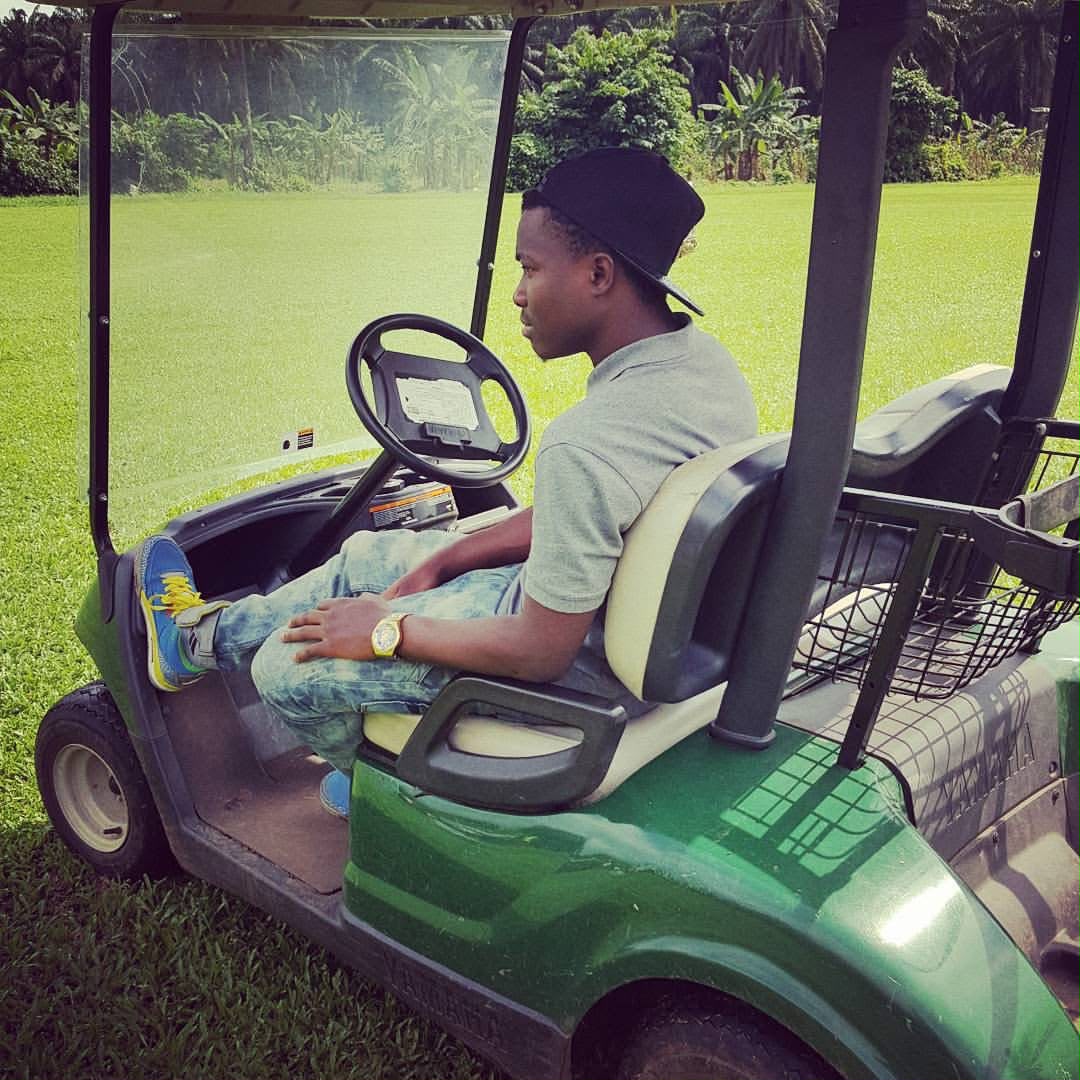 Ikome Princewill seated in a golf cart on a green course